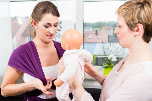 woman learning to use a purple stretchy wrap with a doll