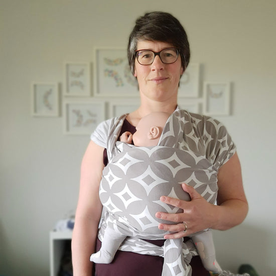 Auckland babywearing consultant from joyriders wearing doll in classic boba stretchy wrap grey with white diamonds