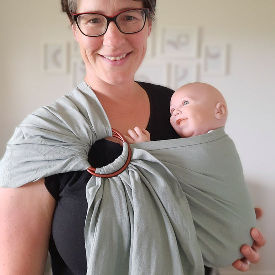Auckland babywearing consultant with demo doll in a chekoh ring sling