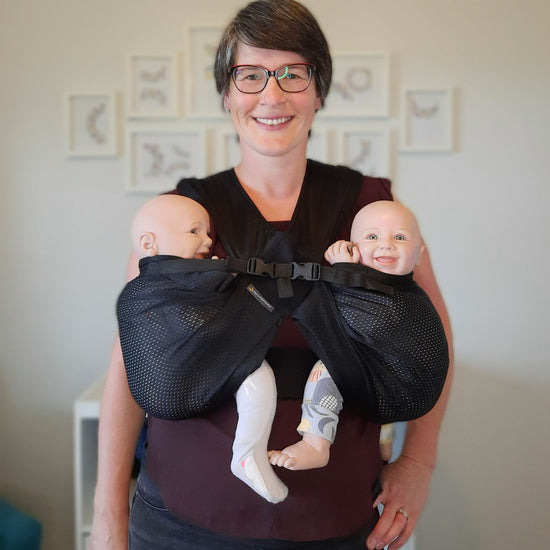Auckland babywearing educator Sarah, wearing twin demo dolls in the mini monkey twin carrier