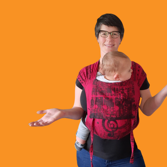 Auckland Babywearing Consultant Sarah wearing a toddler in a red and black meh dai baby carrier