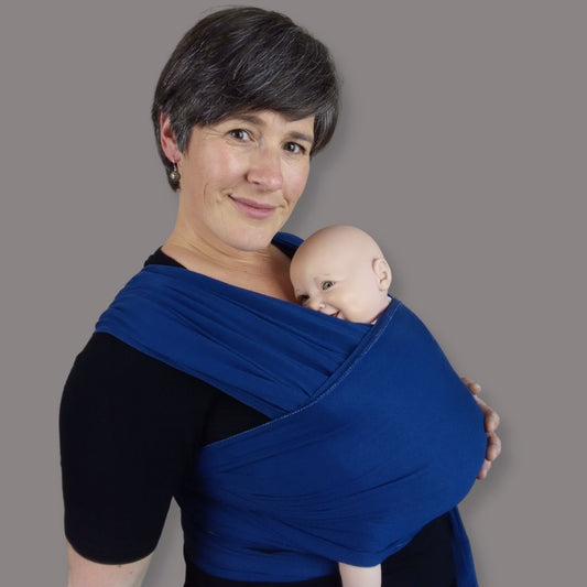 Joy Riders Babywearing Educator with a demonstration doll wrapped in a blue stretchy Wrap